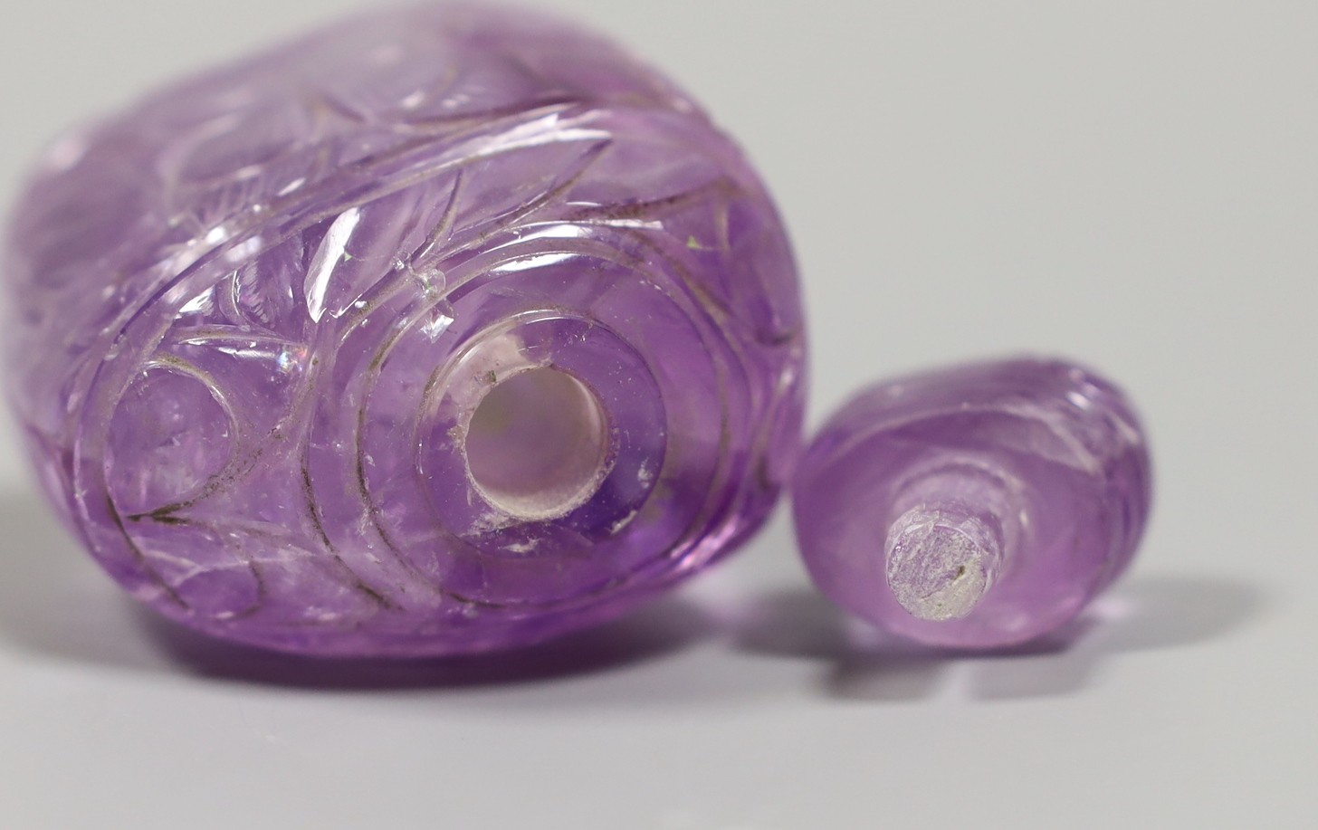 A carved amethyst quartz scent bottle and stopper, 9.5 cms high